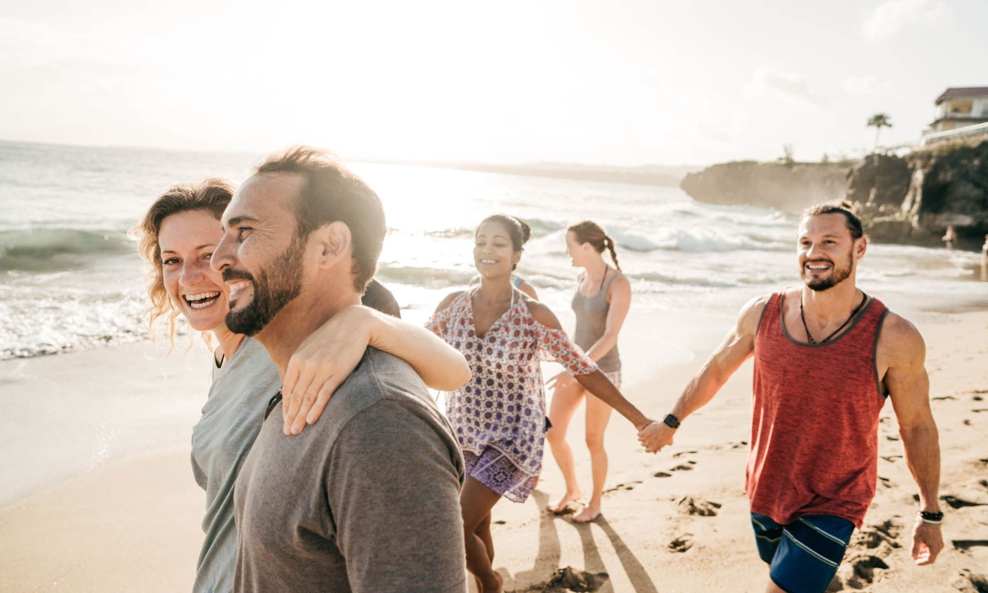 A group of friends are strolling on the beach and feeling grateful for Freshour Group's healthcare solutions for brokers.