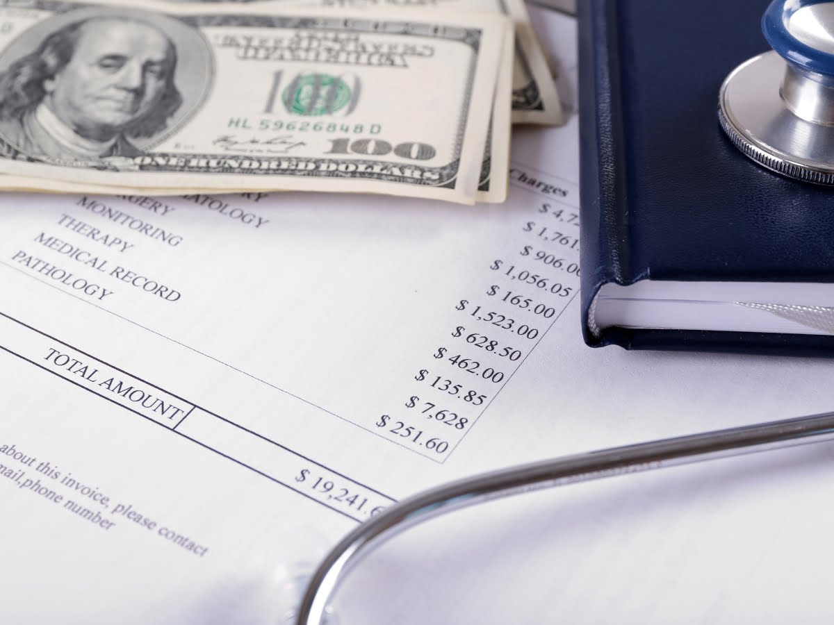 Partners in healthcare - a stethoscope sits on top of a medical bill.