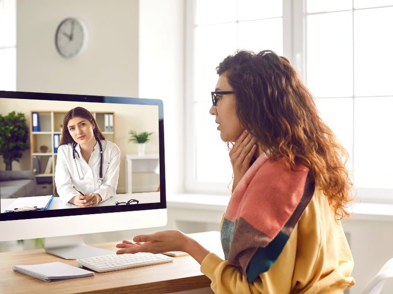 A woman is using a computer to monitor her doctor through a healthcare plan for brokers.